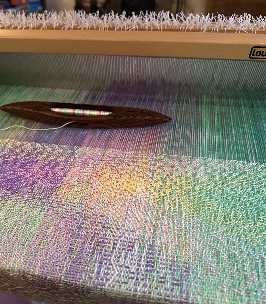 Weaving in progress on a scarf inspired by the soft colours of a rose garden.